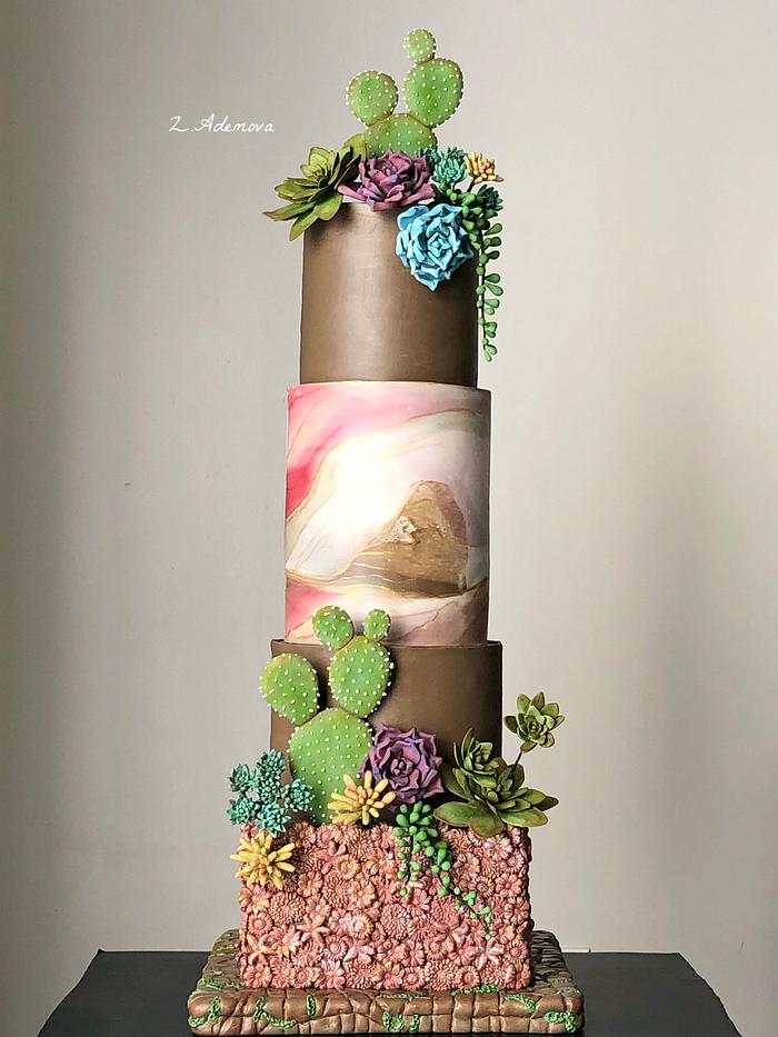 Four tiered cake with earth tones of brown, green and coral decorated with gumpaste succulents and cactus